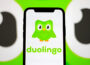 Duolingo app displayed on smartphone next to AI-generated text